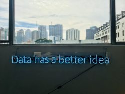 Top half is a cityscape, bottom half has a neon sign that says data has a better idea