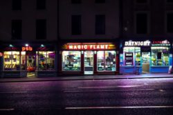 three takeaway shops in a row on street lit up at night