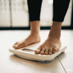 Persons feet stood on weighing scales at home